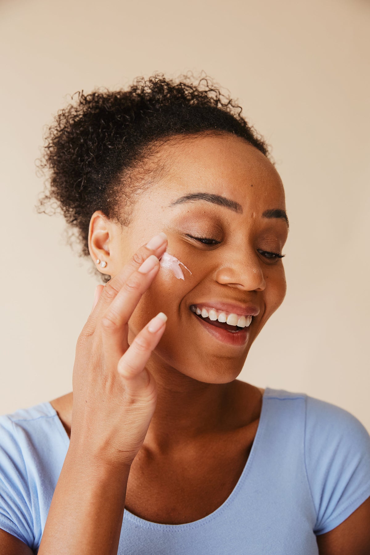 Woman applying moisturizer
